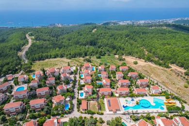 Zonnige villa in Alanya met een privézwembad, stenen accenten en weelderige tropische beplanting.