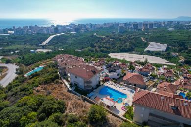 Alanya'da siyah deri kanepeler, ahşap bir sehpa ve parlak, fayans döşemeye sahip oturma odası.