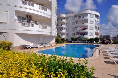 Lichte Alanya appartement woonkamer met een moderne keuken, eierstoel en marmeren vloeren, waardoor een comfortabele sfeer ontstaat.