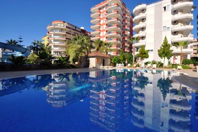 Alanya Immobilien Balkon mit Blick auf den Strand, die Küstenlinie und die helle, sonnige Atmosphäre.