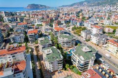 Ruim balkon in Alanya met witte tafel, stoelen en een schilderachtig uitzicht op de bergen.