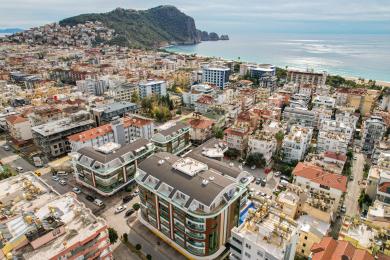 Alanya ejendom luftfoto viser moderne lejlighedsbygninger nær stranden og byen.