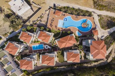 Alanya eiendom balkong med kurvmøbler, glassrekkverk og panoramautsikt over byen og landskapet.