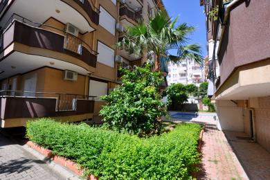 Alanya mulkidagi kafel qoplamali, temir panjarali va yorug', quyoshli muhitli balkon.