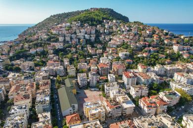 Sunčani balkon u Alanji s namještajem od ratana nudi opuštajući vanjski životni prostor i pogled na bujno zelenilo.