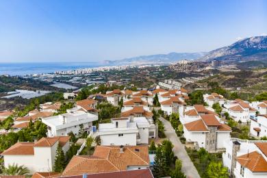 Alanya villa eksteriør med privat basseng, hvit fasade, balkonger og solrik middelhavsatmosfære.