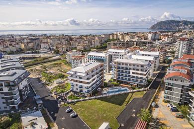 Lyst, tomt rom i Alanya med marmorgulv, innfelt belysning og balkongtilgang gjennom skyvedører.