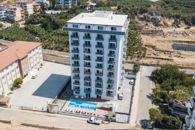 Alanya leilighet stue har et moderne kjøkken, spiseplass og komfortable sitteplasser med lyst, naturlig lys.