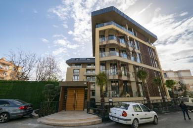 Alanya'daki bu mülkün oturma ve yemek alanı, modern aydınlatma, rahat bir kanepe ve şık bir yemek masası düzenine sahiptir.