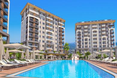 Proprietate în Alanya, dormitor cu paturi twin, lumină naturală blândă, opere de artă cu pești și o paletă de culori neutră și calmantă.