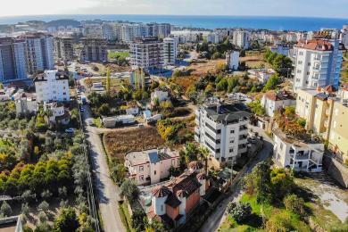 Alanya kinnisvara elutuba, kus on marmorpõrandad, kamin, dekoratiivsed kaared ning neutraalne, hele ja õhuline õhkkond.