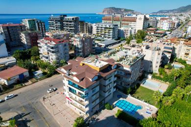 Lys Alanya stue med hvite fliser, moderne møbler, balkongtilgang og varm, innbydende atmosfære.