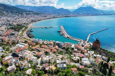 Alanya eiendom balkong med kurvmøbler, blå duk og fantastisk utsikt over Middelhavet.