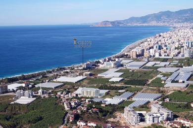 Alanyan asunnon olohuoneessa on marmorinen korostusseinä, takka, moderni valaistus ja mukavat, neutraalin sävyiset istuimet.