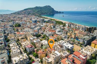 Alanya ejendom altan med kurvemøbler, mønstret flisegulv og en afslappet udendørs spiseatmosfære.