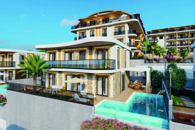 Alanya'daki mülkün modern oturma odasında mermer bir şömine, şık bir mutfak ve okyanus manzaralı aydınlık, havadar bir atmosfer bulunmaktadır.