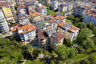 Svetla, otvorena dnevna i trpezarijska zona u Alanji ima podove od pločica, modernu kuhinju i udoban nameštaj.