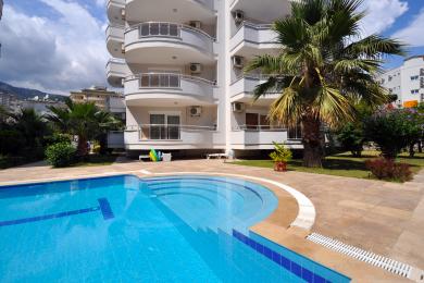 Helles Alanya Schlafzimmer mit Zugang zum Balkon, gelber Bettwäsche und warmer Einbaubeleuchtung schafft eine einladende Atmosphäre.