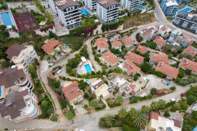 Balconul proprietății din Alanya cu mobilier din răchită, lumină naturală strălucitoare și vederi uimitoare asupra coastei, creând o atmosferă relaxantă.