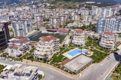 Alanya korteri elutuba rustikaalse puidust laua, hubase diivani ja türgi stiilis valgustusega, mis loob sooja atmosfääri.