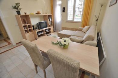 Гасцёўня ў Аланіі з мэбляй са светлага дрэва, бэжавым канапам, кафлянай падлогай і светлай, паветранай атмасферай.