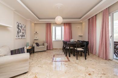 Proprietate în Alanya, living cu podele de marmură, perdele roz și o atmosferă luminoasă și aerisită.