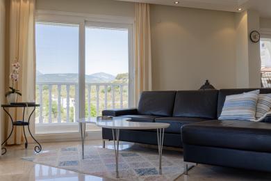 Alanya Wohnzimmer mit Ledersofa, Marmorböden und Balkonblick auf die Berge.