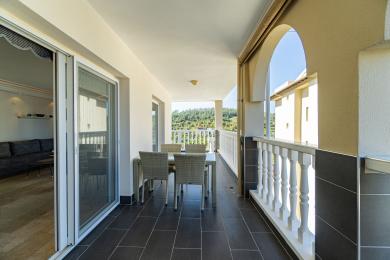 Alanya ejendom balkon med mørkt flisegulv, spisesæt og naturskøn udsigt over bjergene.