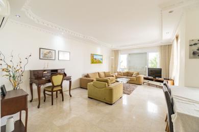 Lys Alanya stue med marmorgulve, komfortable sofaer og et klassisk skrivebord under dekorativ loftudsmykning.