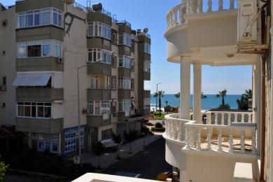 Proprietate în Alanya cu balcon cu balustrade și coloane albe ornamentate, oferind o vedere luminoasă și însorită asupra mării.