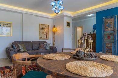 Alanya lejlighed stue med et rustikt træbord, hyggelig sofa og belysning i tyrkisk stil, der skaber en varm atmosfære.
