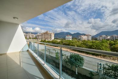 Lys, flisebelagt Alanya-altan med glasrækværk tilbyder en fantastisk udsigt over byen og bjergene.