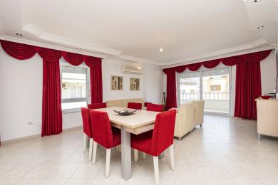 Alanya eiendom stue med lyse fliser, røde gardiner og moderne spisestue med sitteplasser.