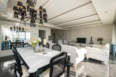 Alanya woning: Elegante woon- en eetkamer met marmeren vloeren, witte meubels en een opvallende kroonluchter.