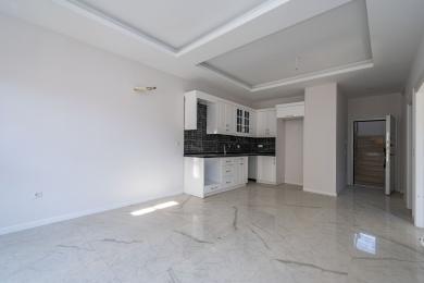 Lyst Alanya-kjøkken med hvite skap, svart backsplash, marmorgulv og mye naturlig lys for en moderne følelse.