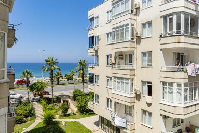 Alanya property view showcasing balconies with ocean views, bright daylight, and a relaxed, coastal atmosphere.
