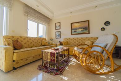 Lys Alanya stue med mønstrede sofaer, marmorgulve og en hyggelig, indbydende atmosfære.