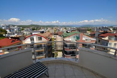 Alanya eiendom balkong med flislagt gulv, metallrekkverk og panoramautsikt over byen og fjellet.