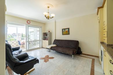 Lichte Alanya woonkamer met marmeren vloeren, toegang tot het balkon, comfortabele zitplaatsen en een warme, uitnodigende sfeer.