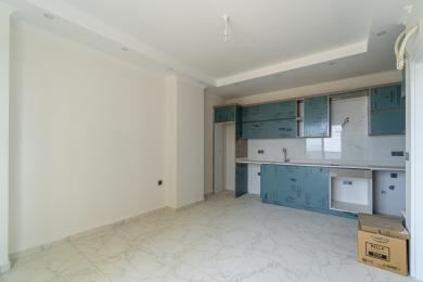 Bucătărie luminoasă în Alanya, cu podele de marmură, pereți albi și dulapuri moderne cu acoperiri de protecție.