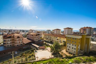 Від на нерухомасць у Аланіі, які дэманструе гарызонт горада, Міжземнае мора і яркае сонца.