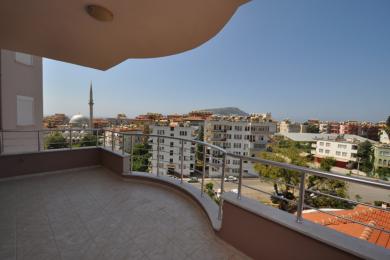 Alanya kinnisvara rõdu plaatpõrandate, roostevabast terasest reelingute ja ereda, päikeselise vaatega linnale.