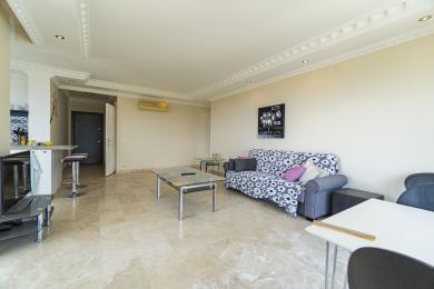 Az alanyai apartman nappalija márványpadlót, semleges falakat és kényelmes, virágmintás kanapét kínál.