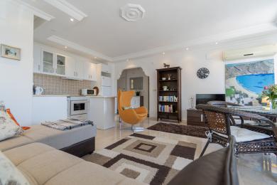 Helles Alanya Apartment Wohnzimmer mit moderner Küche, Eiersessel und Marmorböden, das eine komfortable Atmosphäre schafft.