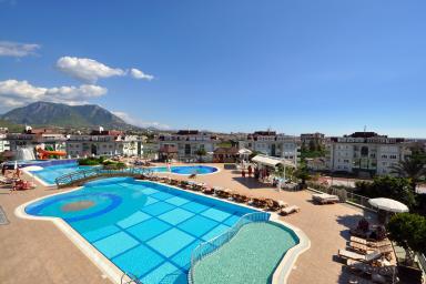 Συγκρότημα κατοικιών διακοπών στην Αλάνια με θέα σε ένα μεγάλο συγκρότημα πισίνας με θέα στο βουνό, ιδανικό για χαλαρωτικές διακοπές στην Τουρκία.