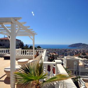 Alanya feriebolig balkonudsigt: Middelhavet, byens skyline og en solrig, afslappet atmosfære.