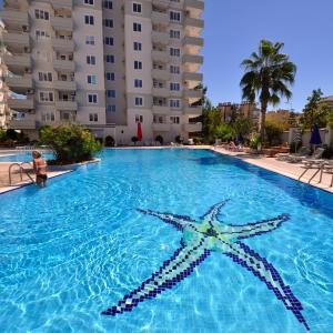 Luksuriøst Alanya feriebolig kompleks med en stor swimmingpool og afslappende atmosfære.