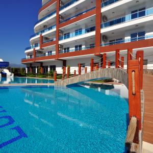Luxuriöses Alanya-Ferienhaus mit Pool, Wasserrutsche und Brücke, das eine entspannende Urlaubsatmosphäre bietet.