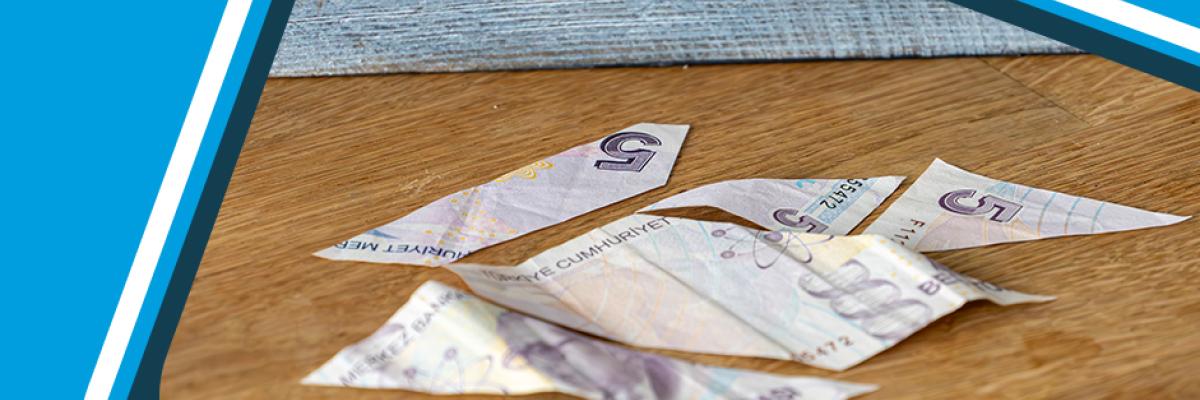 Flere muligheder for alt-teksten, med fokus på forskellige aspekter og toner: En iturevet tyrkisk lira nær et modelhus, der repræsenterer de finansielle risici ved investering i ejendomme i Alanya.
