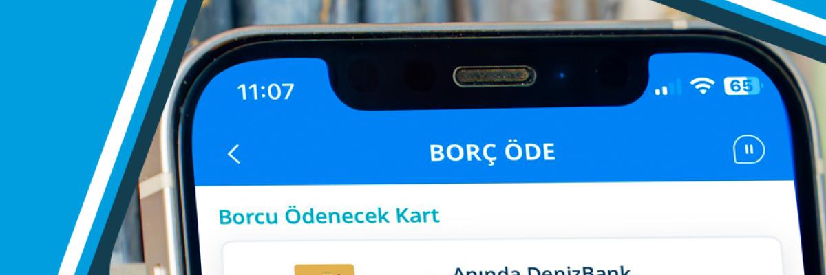 پرداخت آنلاین قبوض در آلانیا، ترکیه؛ کارت طلایی DenizBank MasterCard روی صفحه نمایش گوشی هوشمند.